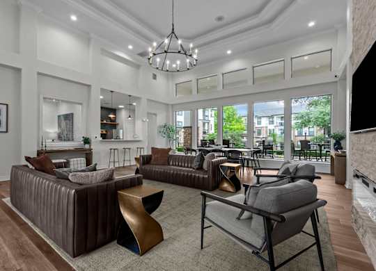 A modern living room with a brown sofa and a grey armchair.