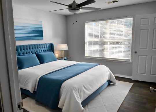 a bedroom with a blue and white bed and a ceiling fan