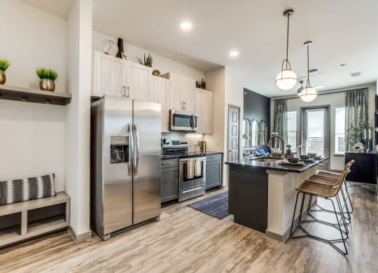 an open kitchen with stainless steel appliances and a large island