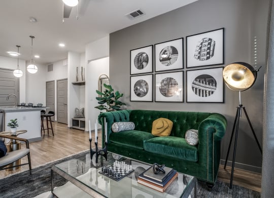 a living room with a green couch and a glass table