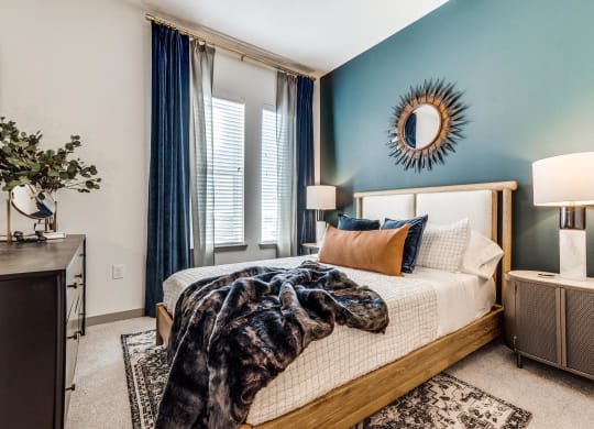 a bedroom with blue walls and a bed with a blanket
