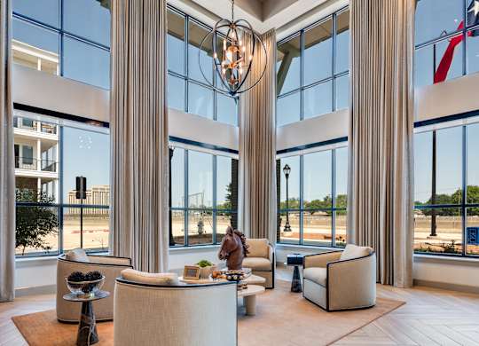 A large, modern living room with a high ceiling and a large chandelier.