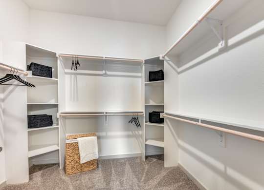 A white closet with a basket on the floor.
