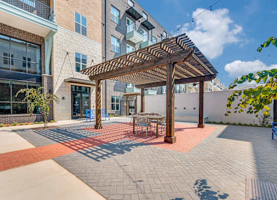 A patio with a table and chairs under a pergola.