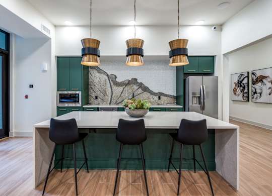 A kitchen with a bar and chairs.