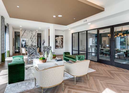 A modern living room with a green sofa and a white armchair.