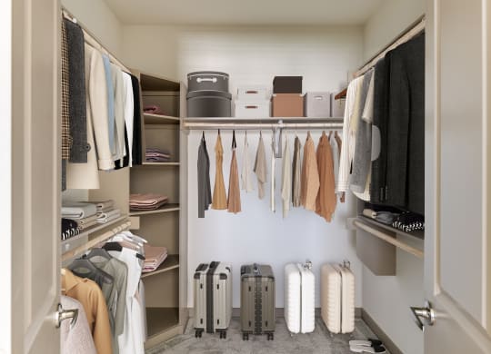 a walk in closet filled with luggage and clothes