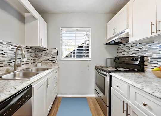 a kitchen with white cabinets and granite counter tops and a sink