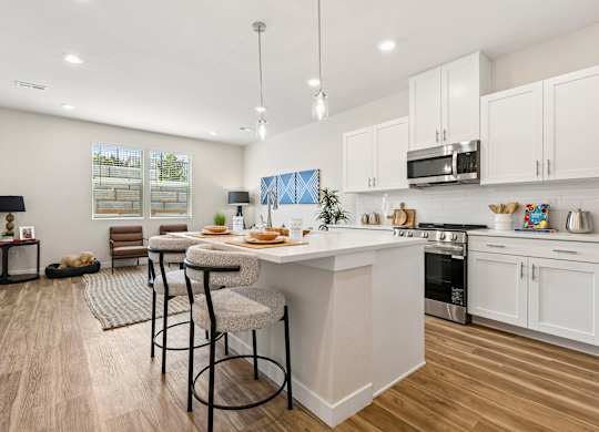 A modern kitchen with a dining area and a view of the backyard.