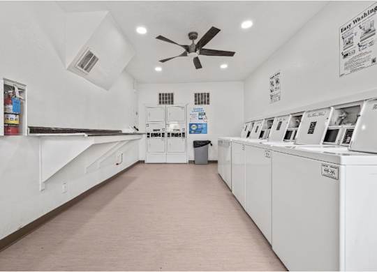 a laundry room with white appliances and a ceiling fan