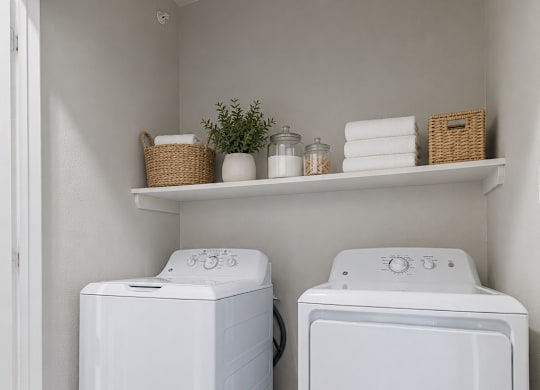 Two white front load washing machines in a laundry room.