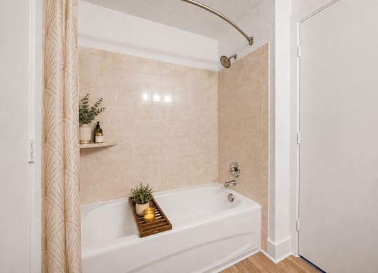 A bathroom with a white tub and a shower curtain.