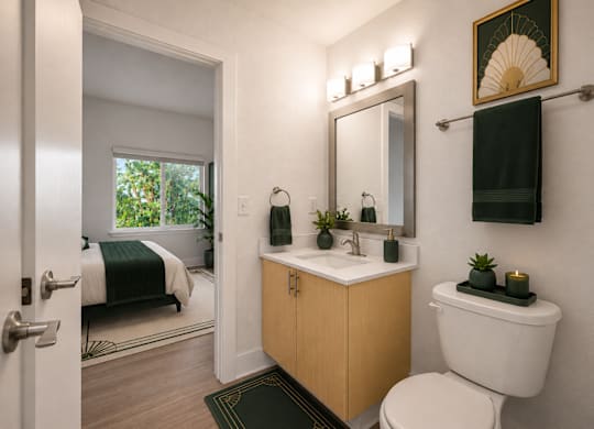A bathroom with a toilet, sink, and mirror.