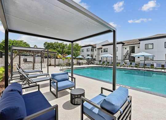 A poolside area with lounge chairs and a canopy.