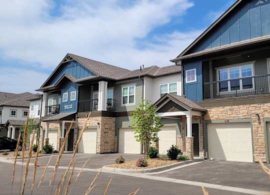 A row of houses with garages and driveways.