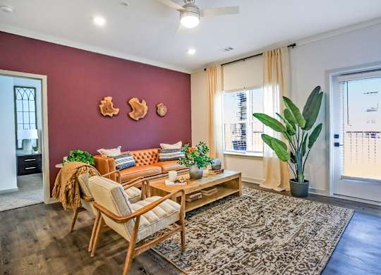 A living room with a sofa, chair, and potted plants.