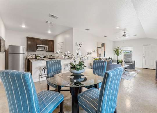 a living room and dining room with blue chairs and a table