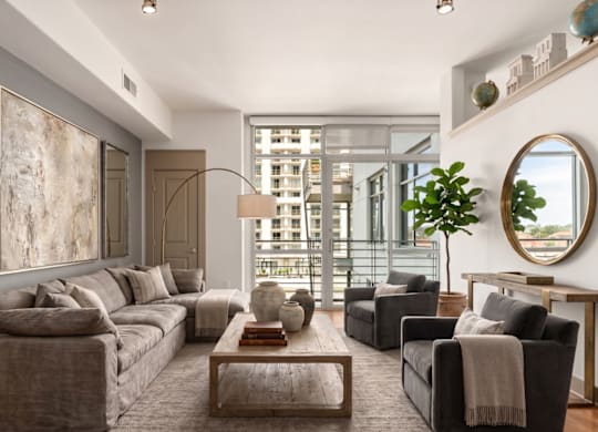 A living room with a grey couch, a coffee table, and a large painting on the wall.