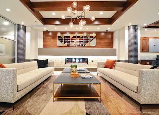 A modern living room with a glass coffee table and two couches.