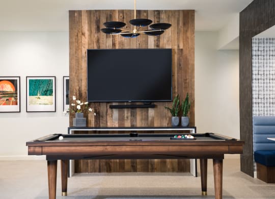 a living room with a pool table and a tv on the wall