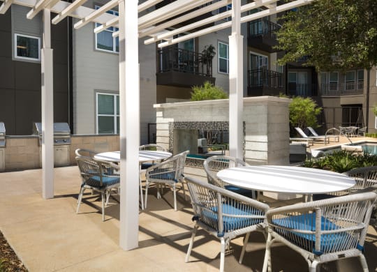 a patio with tables and chairs and a fire place