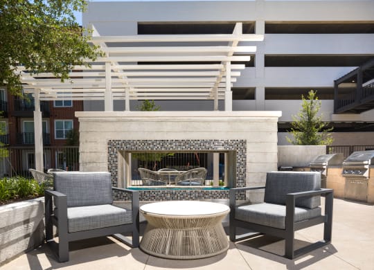 a patio with chairs and a table and a fireplace