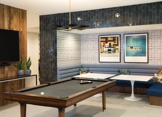 a games room with a pool table and a television
