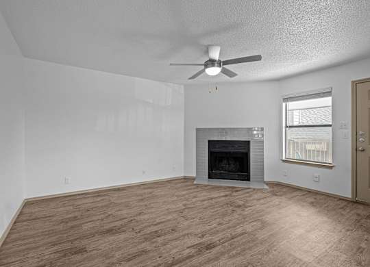 A room with a fireplace and a ceiling fan.