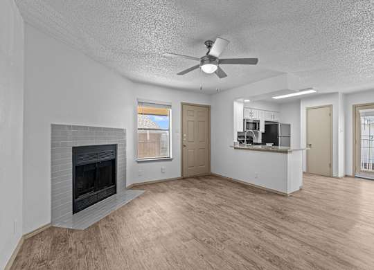 A living room with a fireplace and a ceiling fan.