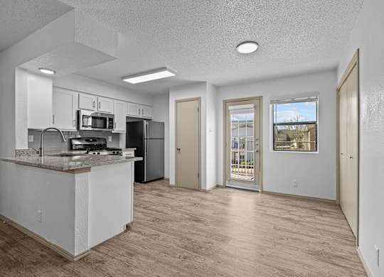 A kitchen with a counter and a fridge.