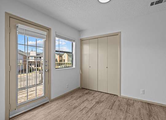 A room with a door, a window, and a wall-mounted cabinet.