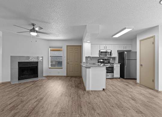 A spacious kitchen with a fireplace and a refrigerator.