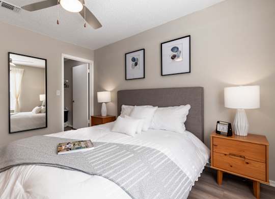 A bedroom with a large bed and a ceiling fan.