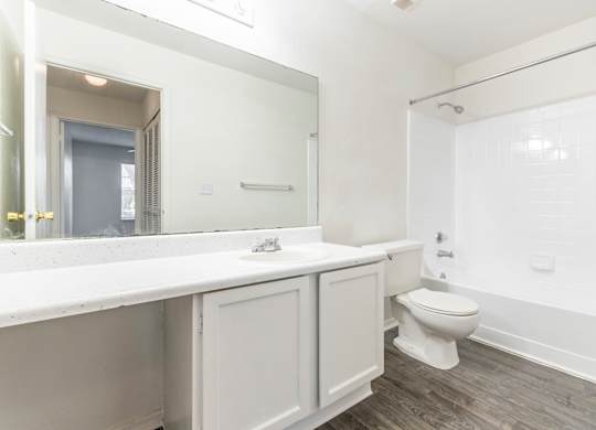 A white bathroom with a toilet, sink, and bathtub.