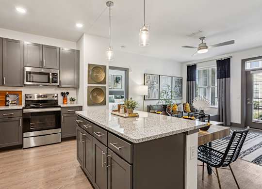 A modern kitchen with a large island and stainless steel appliances.