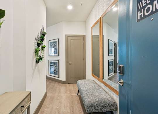 A hallway with a bench and a door with a sign that says