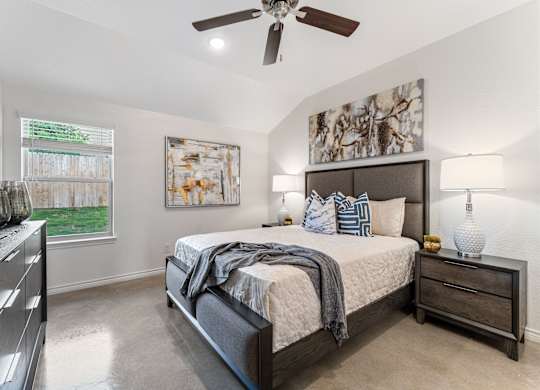 the master bedroom in a new home with a ceiling fan