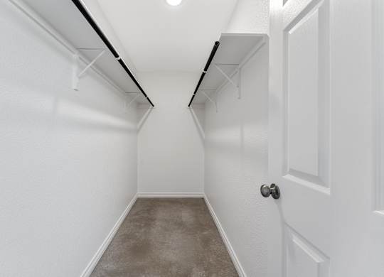 an empty room with white walls and a concrete floor and a white door