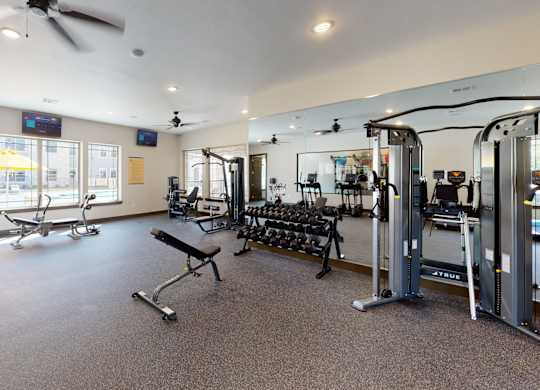A spacious gym with a variety of equipment including treadmills, weights, and exercise machines.