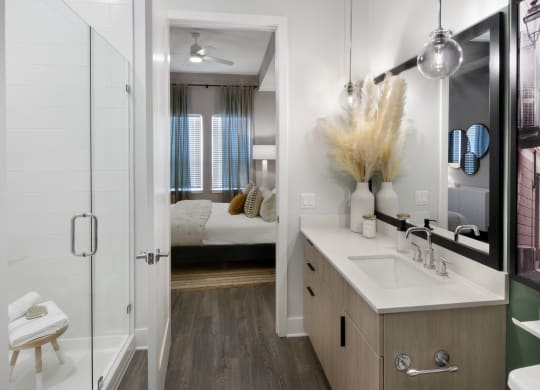 a bathroom with a shower and a sink and a mirror