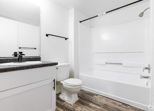 A white bathroom with a toilet, sink, and bathtub.