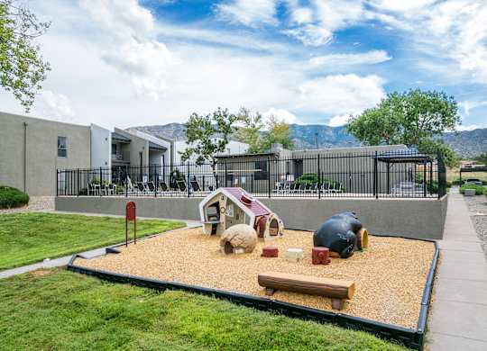 A playground with a sandbox and a bench.