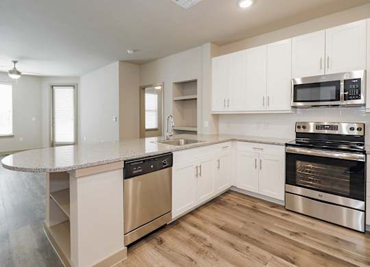 A kitchen with stainless steel appliances and white cabinets.