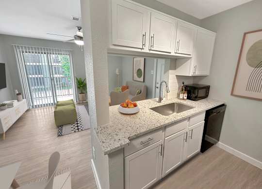 A kitchen with white cabinets and a granite countertop.