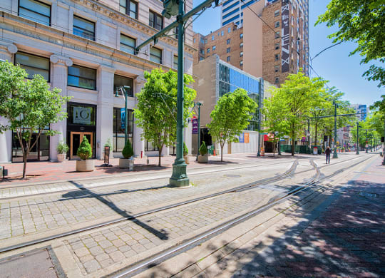a city street with streetcar tracks and a building in the background
