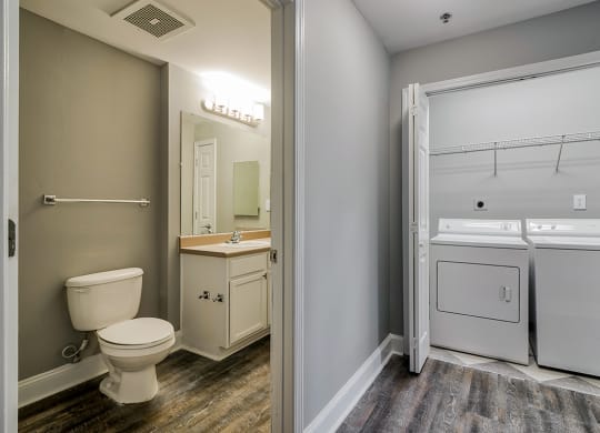 a bathroom with a toilet and a washer and dryer