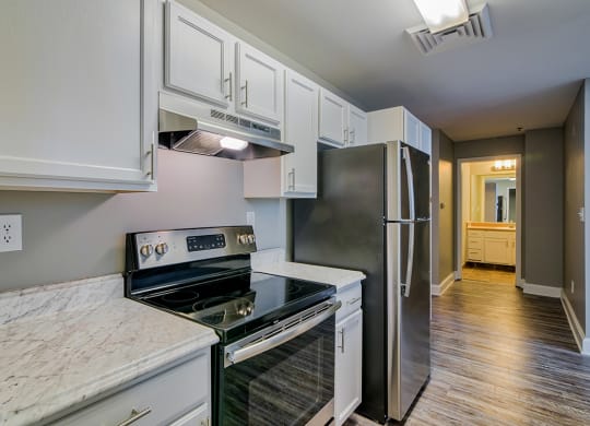 a kitchen with white cabinets and stainless steel appliances