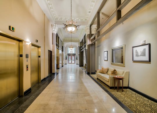 a large hallway with a chandelier and a couch