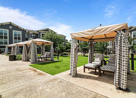 A patio area with a table and chairs under a canopy.