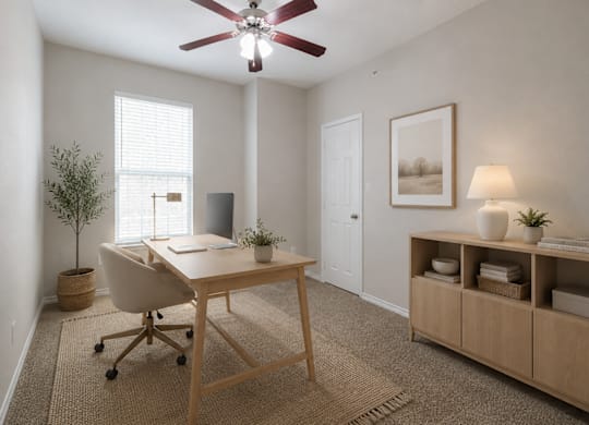 A room with a desk, chair, and a ceiling fan.